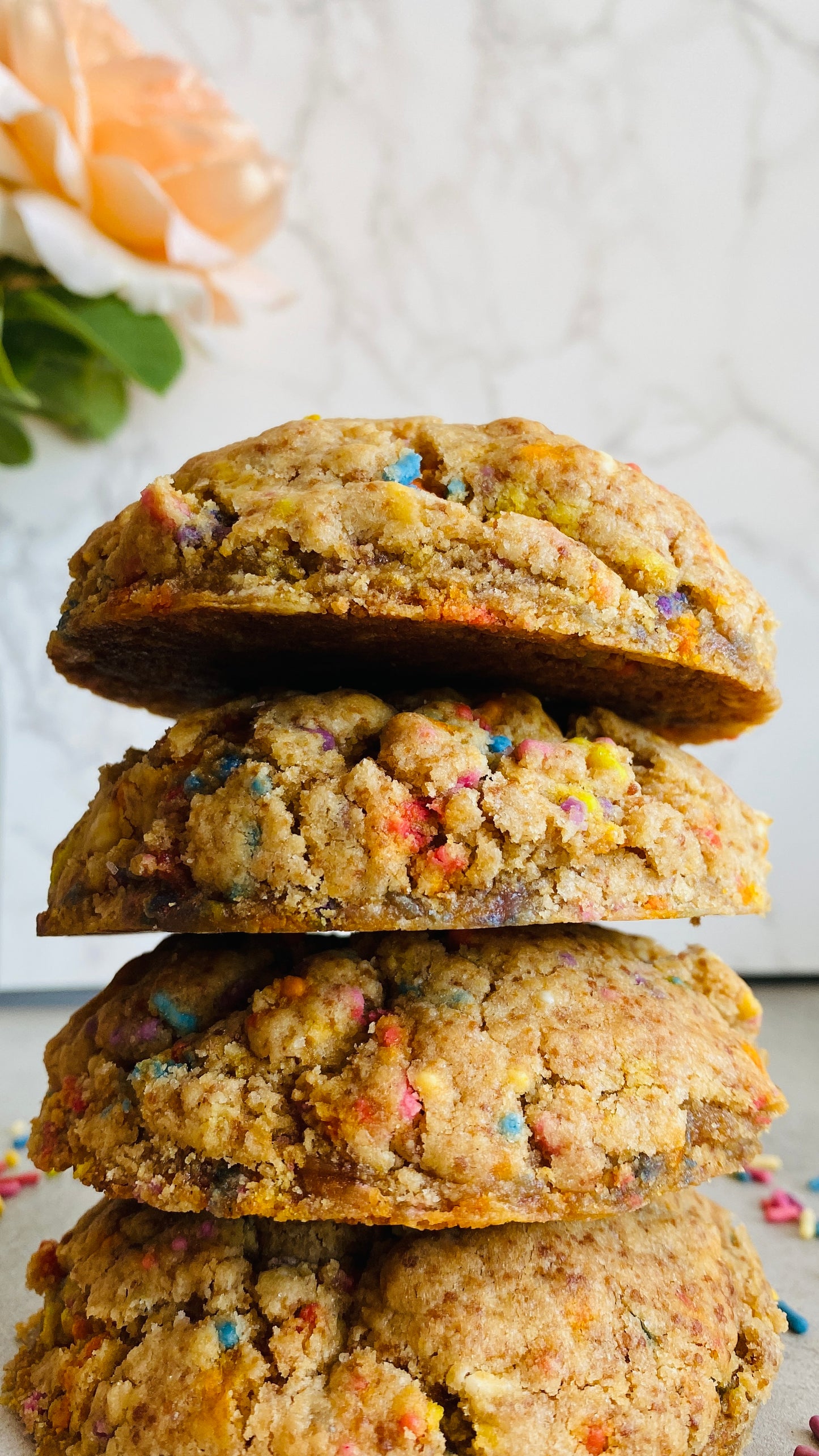 Stack of colorful cookies with a blurred floral background