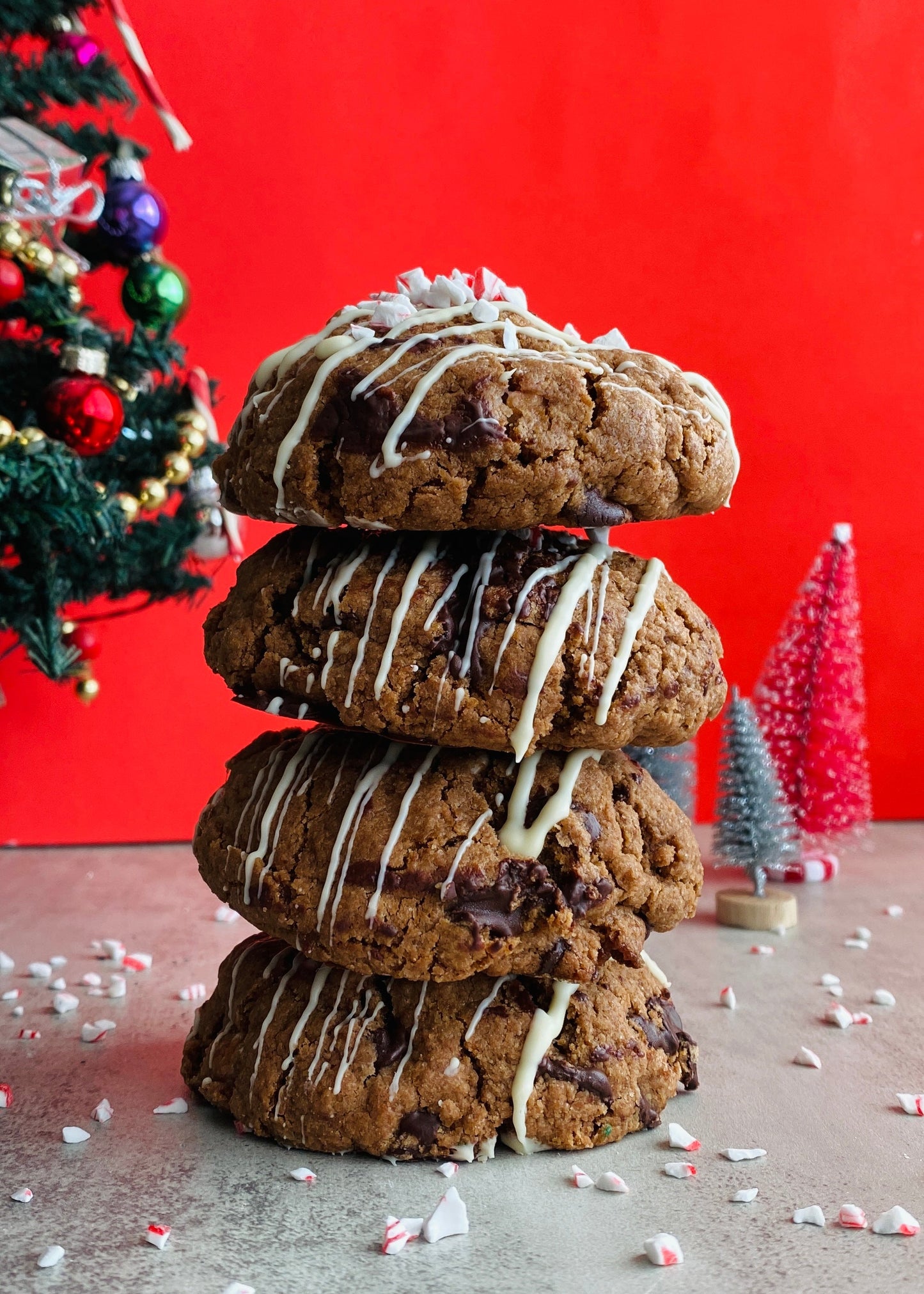 Stack of cookies with a Christmas tree and red wall in the background