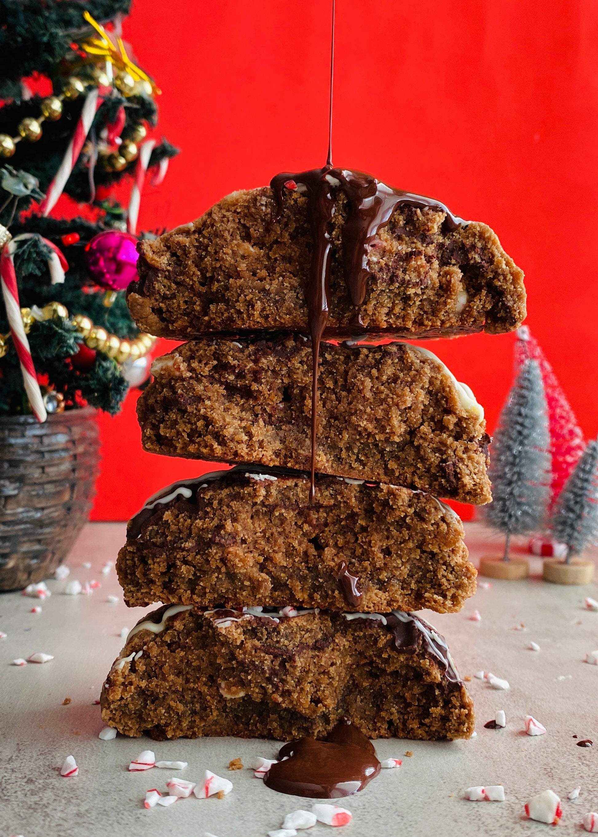 Stack of chocolate-covered cookies with a Christmas tree in the background